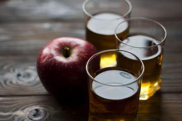 red Apple with Apple juice on a wooden table close up