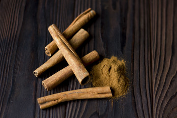Cinnamon sticks and meal close up on wooden table