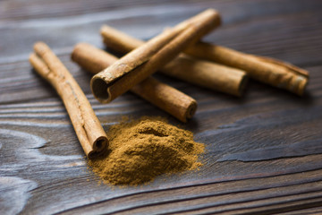 Cinnamon sticks and meal close up on wooden table