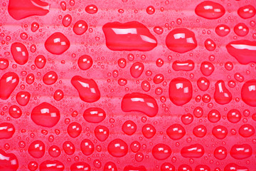 Abstract background of water droplets on red surface.