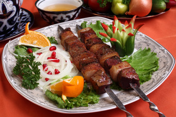Kebab of beef liver with sheep's tail fat.Served with chopped spring onions with pomegranate,herbs and lemon.Uzbek cuisine