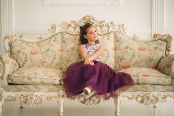 Beautiful girl in a purple dress and flower blouse posing for a photographer.