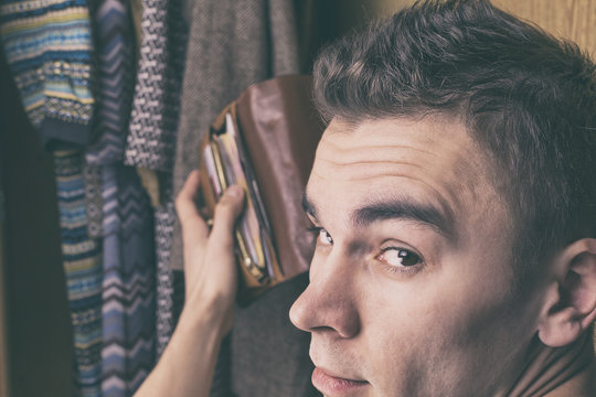 A young man steals money from wallet