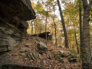 Rocks and hills in an autumn forest with colorful foliage
