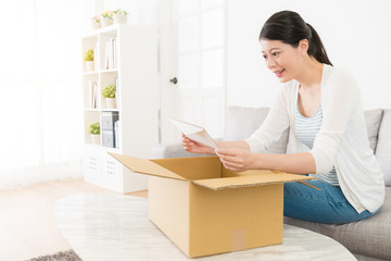 beautiful girl sitting on sofa holding envelope