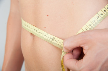 frau misst Bodymass mit Messband