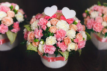 Flower arrangement of white and pink roses at the dark background. Wedding ceremony.
