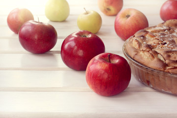 pastry with fruit/ lush and ruddy pie on the background of apples on the table front view