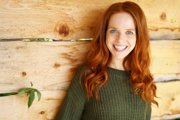 glückliche frau mit langen roten haaren und blauen augen