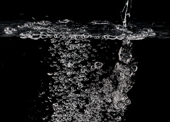stream of bubbles under water on a black background