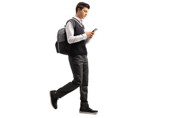 Obraz premium Teen student walking and using a phone