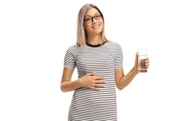Satisfied young woman with a glass of water holding her hand on her stomach