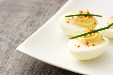 Stuffed eggs with mustard,mayo and paprika on wooden table