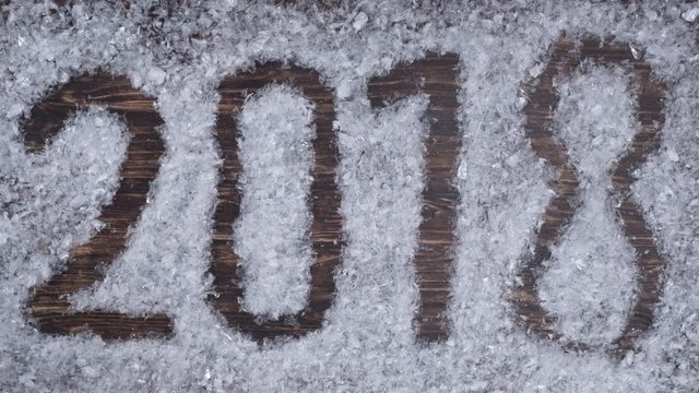 The snowdrift on the table turns into an inscription 2018 Time lapse prores 4444 4k