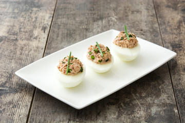 Stuffed eggs with tuna on wooden table