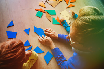 teacher and kids playing with geometric shapes puzzle