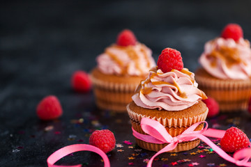 Raspberry and caramel cupcakes on dark background