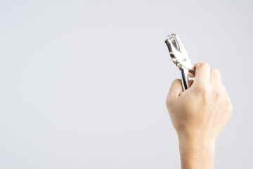 Hand holding silver paper punch one round hole for office work