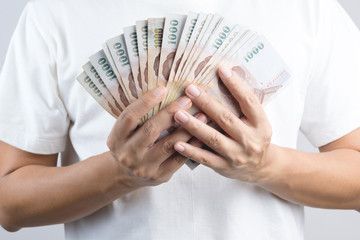 Hand holding Thai banknotes of 1000  baht or money currency in Thailand