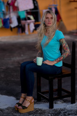 The modern housewife sitting on the chair in the background hanging linen. Doomed species. The modern woman.