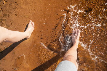 Splashing water with foot on sand beach
