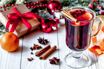 Christmas mulled wine with spices in cup on wooden background