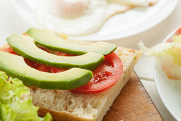 Sliced avocado, tomatoes, cucumber on a fresh ciabatta bread
