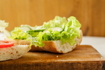 Sliced tomatoes, cucumber and salad leaves on a fresh ciabatta bread