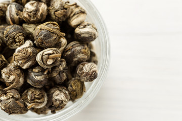 Dry tea balls in a small glass dish top view, copy space