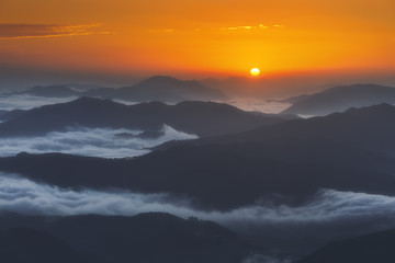Fototapeta na wymiar sunrise on distant mountains with morning fog