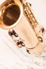 Part of saxophone lying on the notes