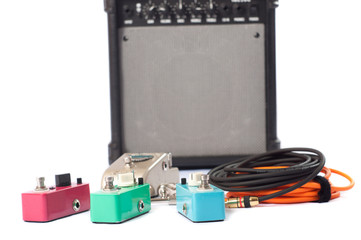 Electric guitar stomp effectors and cables in studio. Focus is on forehand switch box.