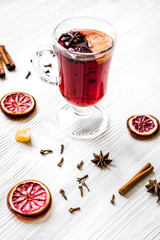 mulled wine with spices in cup on wooden background
