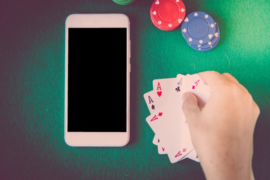 blank screen smartphone, chips and cards over poker table. Gambling concept.