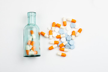 Different medications and pills with vintage pharmacy bottles on a white background