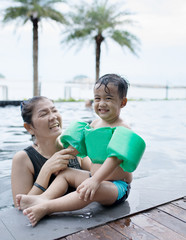 Fototapeta na wymiar asian children and mother playing in sport water pool smiling face happiness emotion