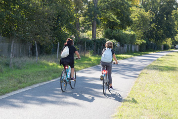 two women biking on a bike path