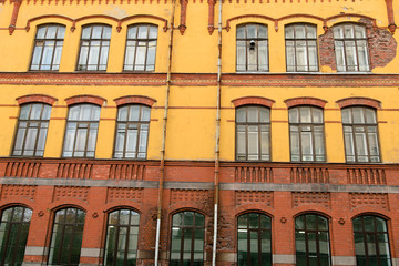 Fototapeta na wymiar Facade of old yellow-red building in Vyborg, Russia