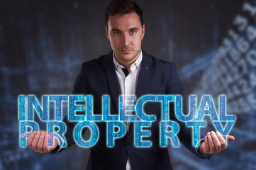 The concept of business, technology, the Internet and the network. Young businessman showing inscription: Intellectual property