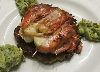 a beautiful plate with fish, ham, potatoes and a little green vegetables