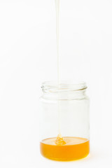 Pouring Fresh Honey into Glass Jar