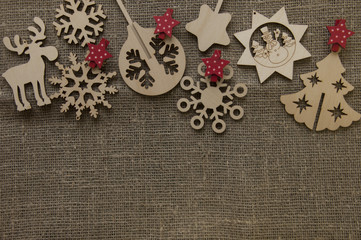 Christmas wooden figures on canvas background with red stars and toys