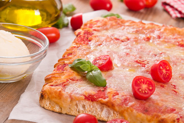 Italian pizza with cheese, tomatoes and fresh basil. 