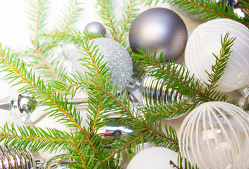 Fototapeta na wymiar Christmas or New Year background: silver glass toys and balls, fir tree branches, decoration on white background. 