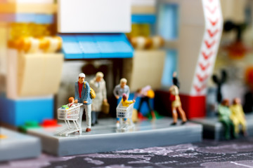 Miniature people family with shopping cart in supermarket, Tourism, shopping or business concept..