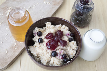 Delicious oatmeal porridge with berry and almonds for breakfast.