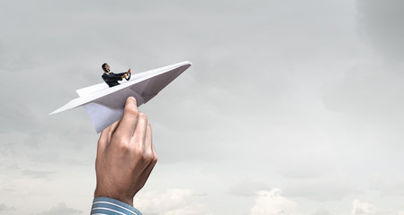 Woman pilot in paper plane. Mixed media