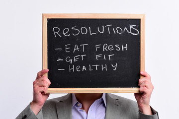 Male hands hold blackboard with sign pointing healthy lifestyle resolutions