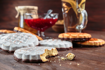 cookies with white chocolate frosting and raspberry jam in a little vase on the table for tea