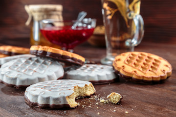 cookies with white chocolate frosting and raspberry jam in a little vase on the table for tea